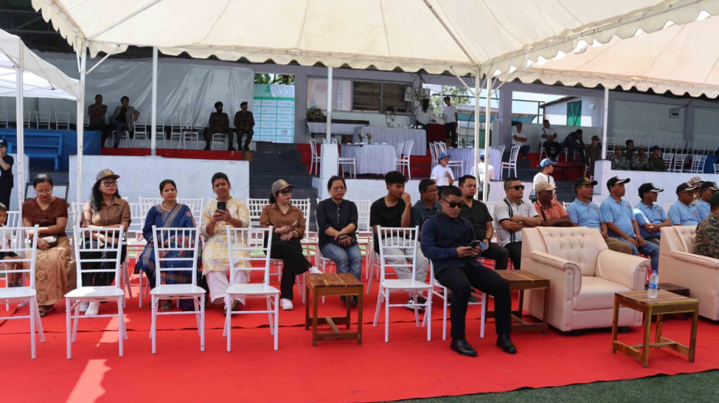 Audience and dignitaries seated under a large white tent during the programme.