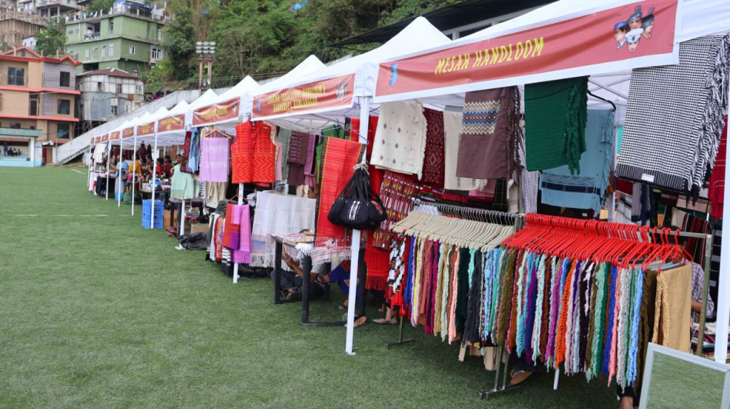 Handloom and traditional Mizo textile stalls displaying colourful puan and handicrafts.