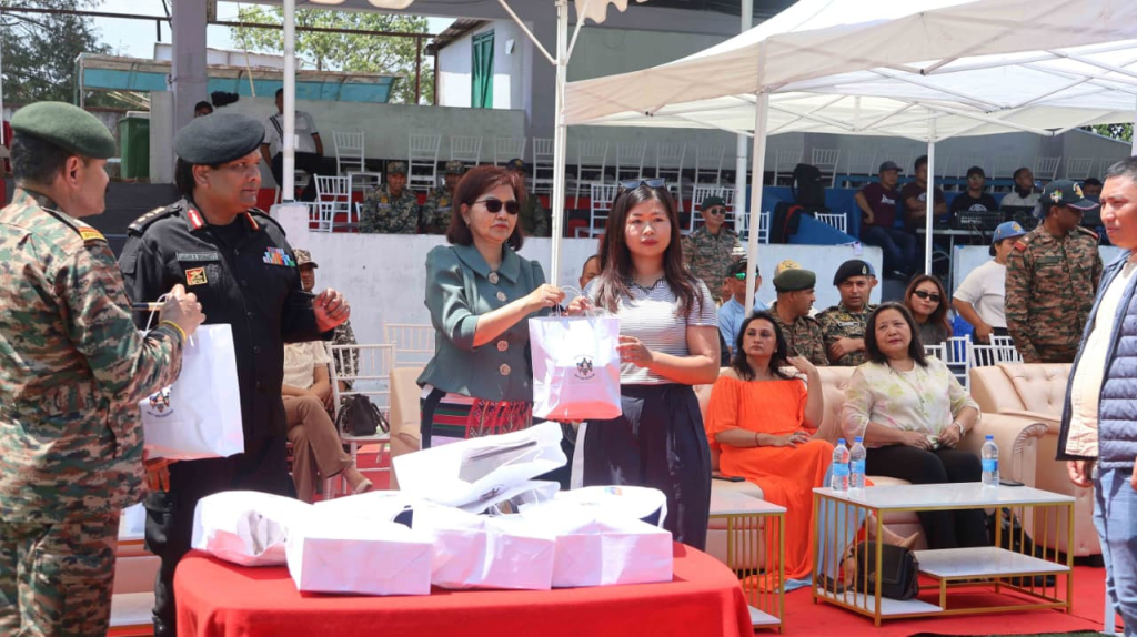 Minister Pi Lalrinpuii distributing gift bags to participants at a table during the NCC event.